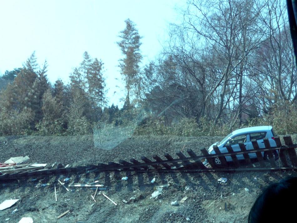 ①津波で変形した線路と打ち上げられた軽自動車(JR山田線)